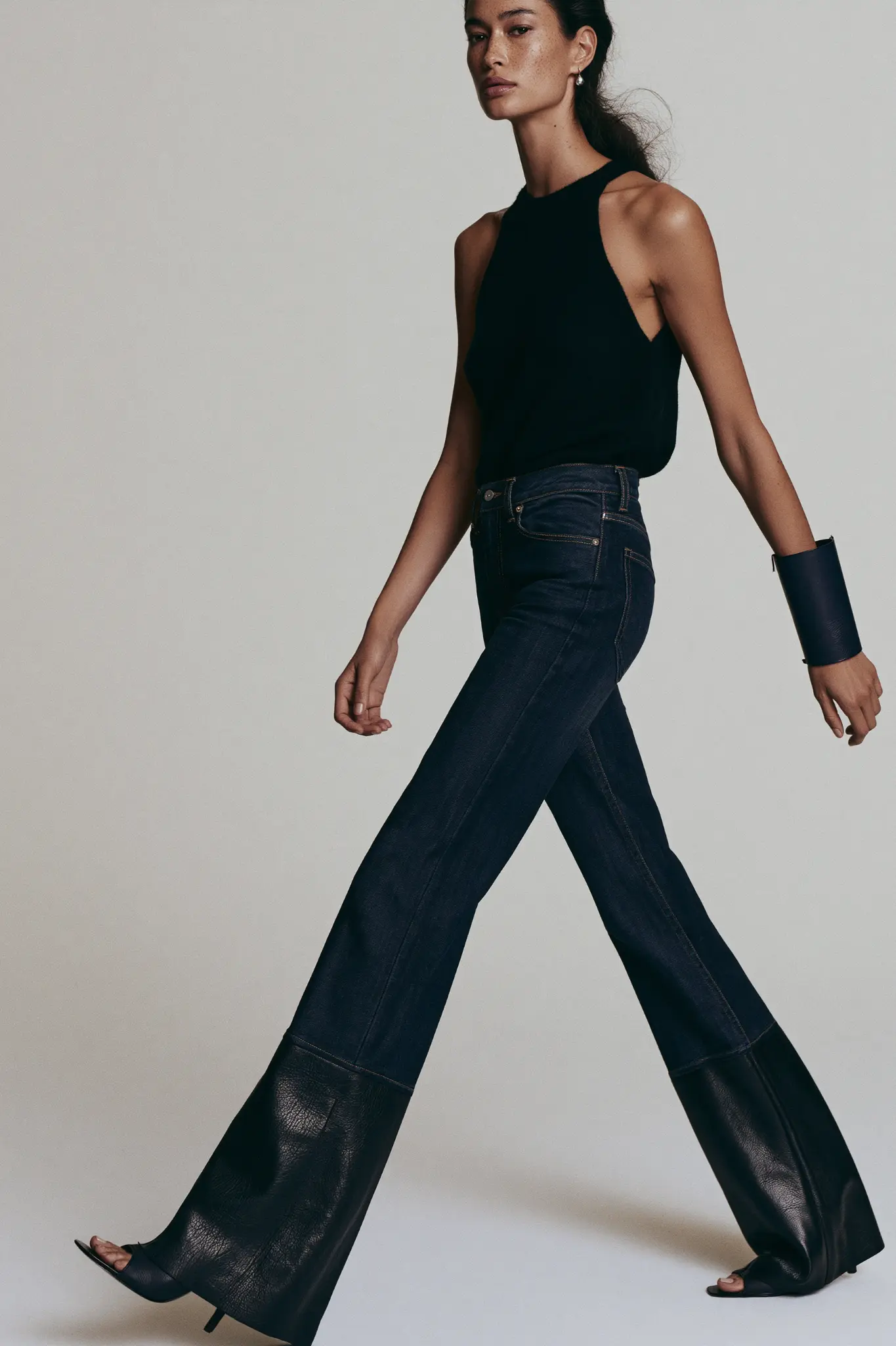 Studio fashion study showing the pressed indigo leg and tonal nappa leather construction